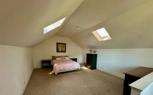 a spacious bedroom with a bed and a window