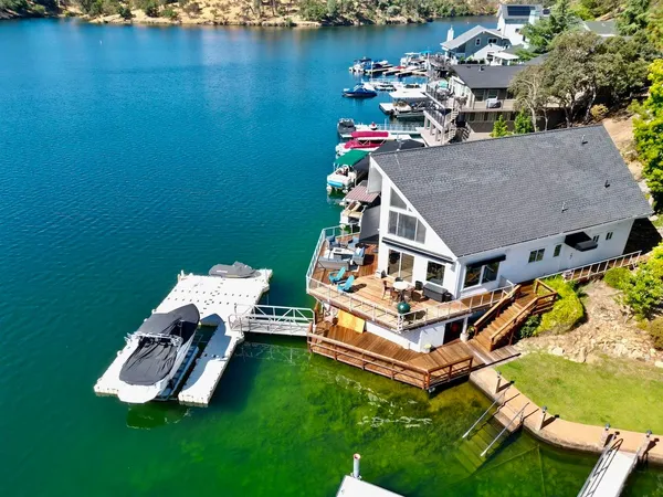 an aerial view of a house with swimming pool garden view and a lake view