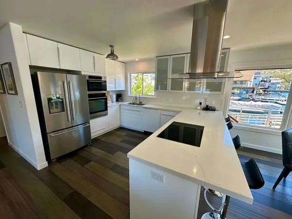 a kitchen with granite countertop a sink a counter space stainless steel appliances and cabinets