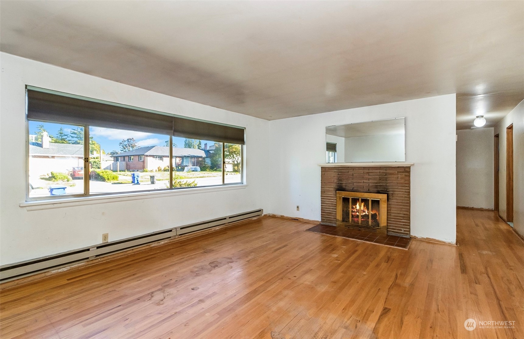 2416 6th Street Everett, WA 98201 - Photo 16 of 36 an empty room with wooden floor fireplace and windows
