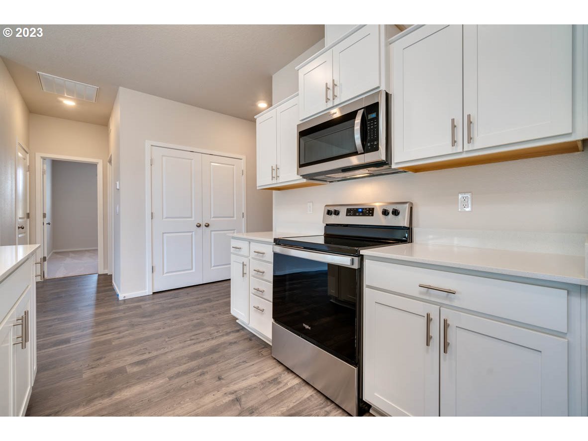3492 Southeast Olvera Avenue Gresham, OR 97080 - Photo 12 of 23 a kitchen with stainless steel appliances granite countertop a stove a microwave and white cabinets