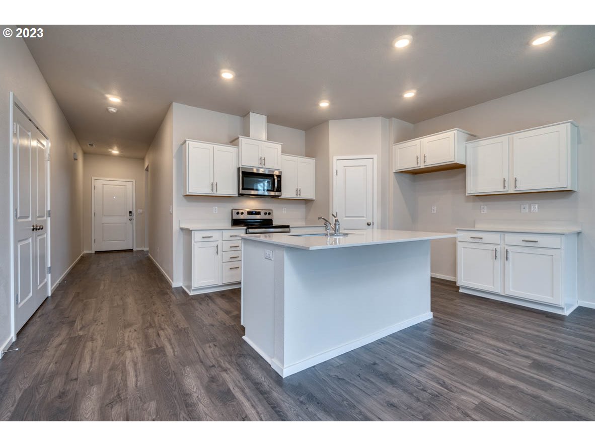 3492 Southeast Olvera Avenue Gresham, OR 97080 - Photo 9 of 23 a kitchen with stainless steel appliances kitchen island granite countertop a stove a sink and a refrigerator