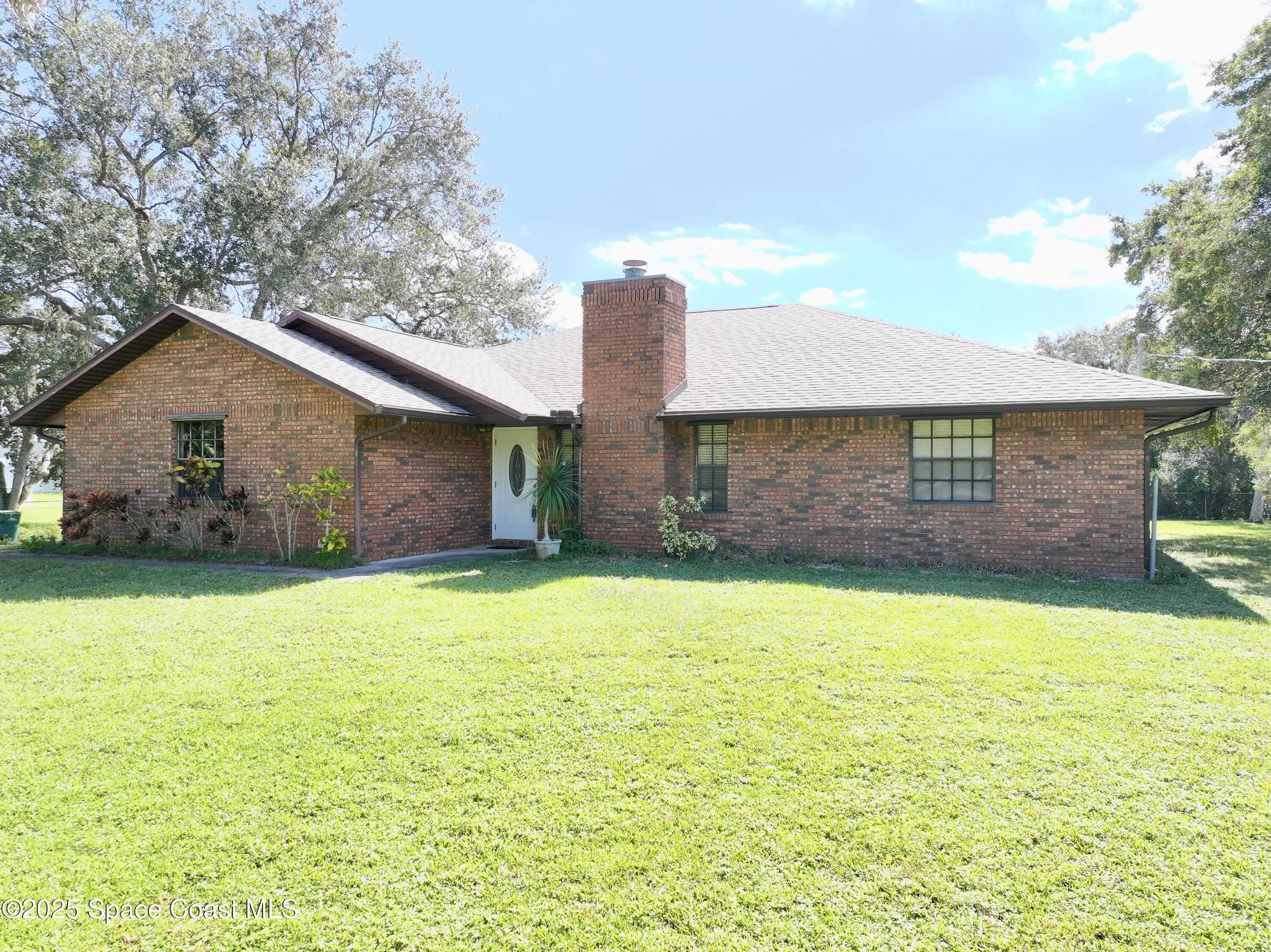 3301 Grant Road Grant-Valkaria, FL 32949 - Photo 1 of 56 a front view of a house with a yard and garage