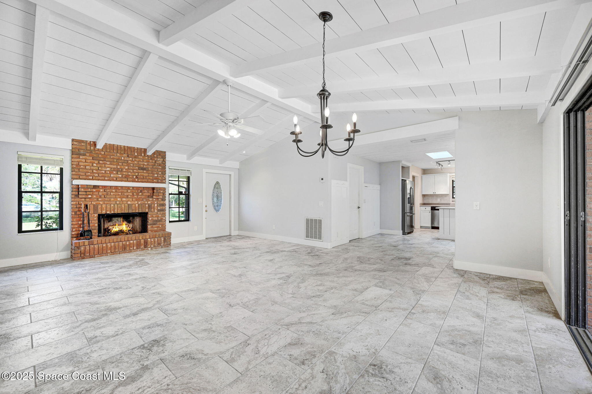 3301 Grant Road Grant-Valkaria, FL 32949 - Photo 10 of 56 a view of a livingroom with a fireplace a chandelier and stairs