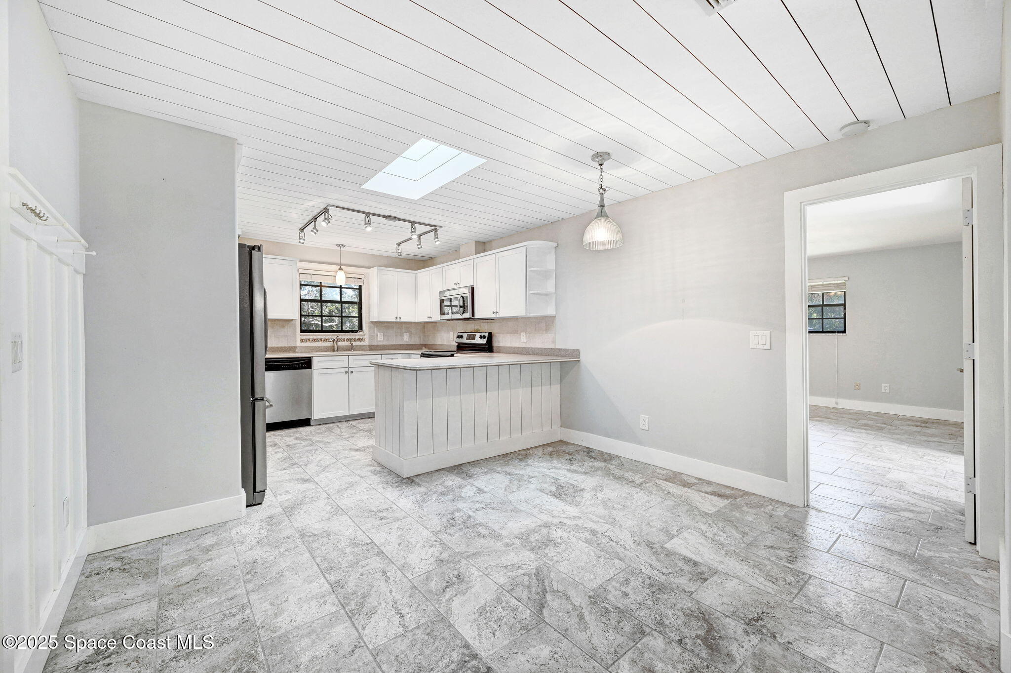 3301 Grant Road Grant-Valkaria, FL 32949 - Photo 13 of 56 a kitchen with stainless steel appliances kitchen island a refrigerator sink and cabinets