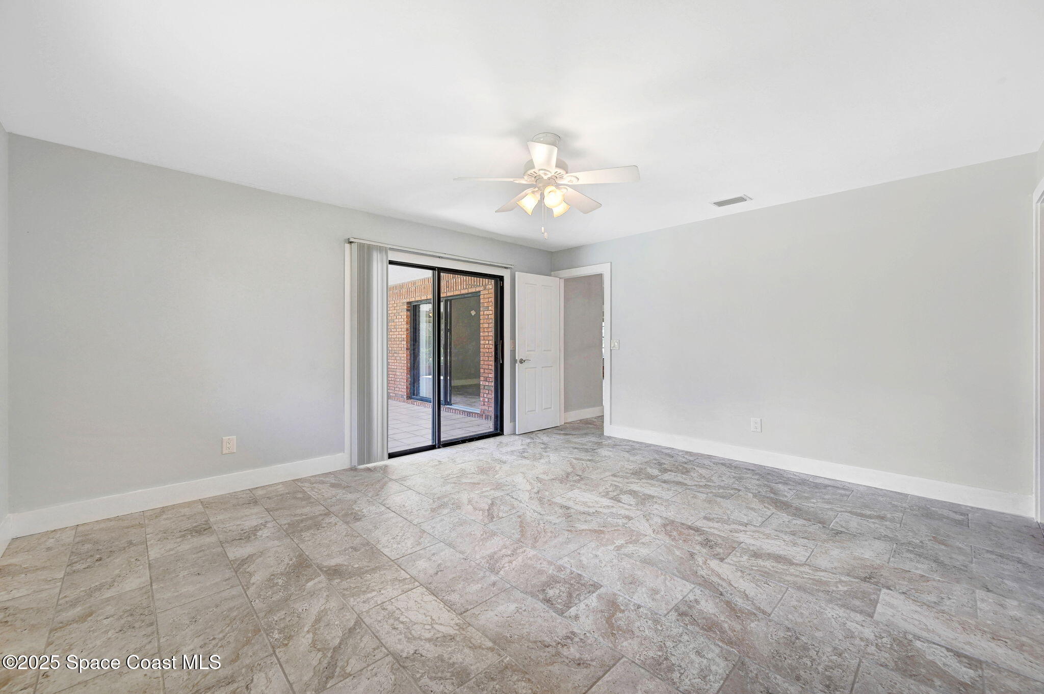 3301 Grant Road Grant-Valkaria, FL 32949 - Photo 20 of 56 an empty room with chandelier fan and windows