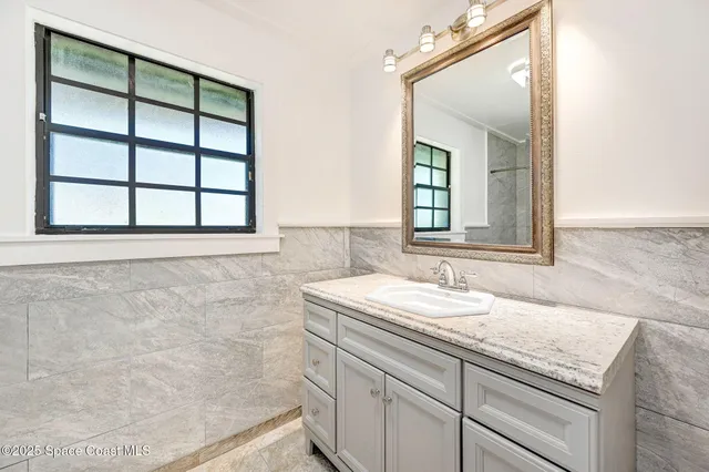 a bathroom with a granite countertop sink and a mirror