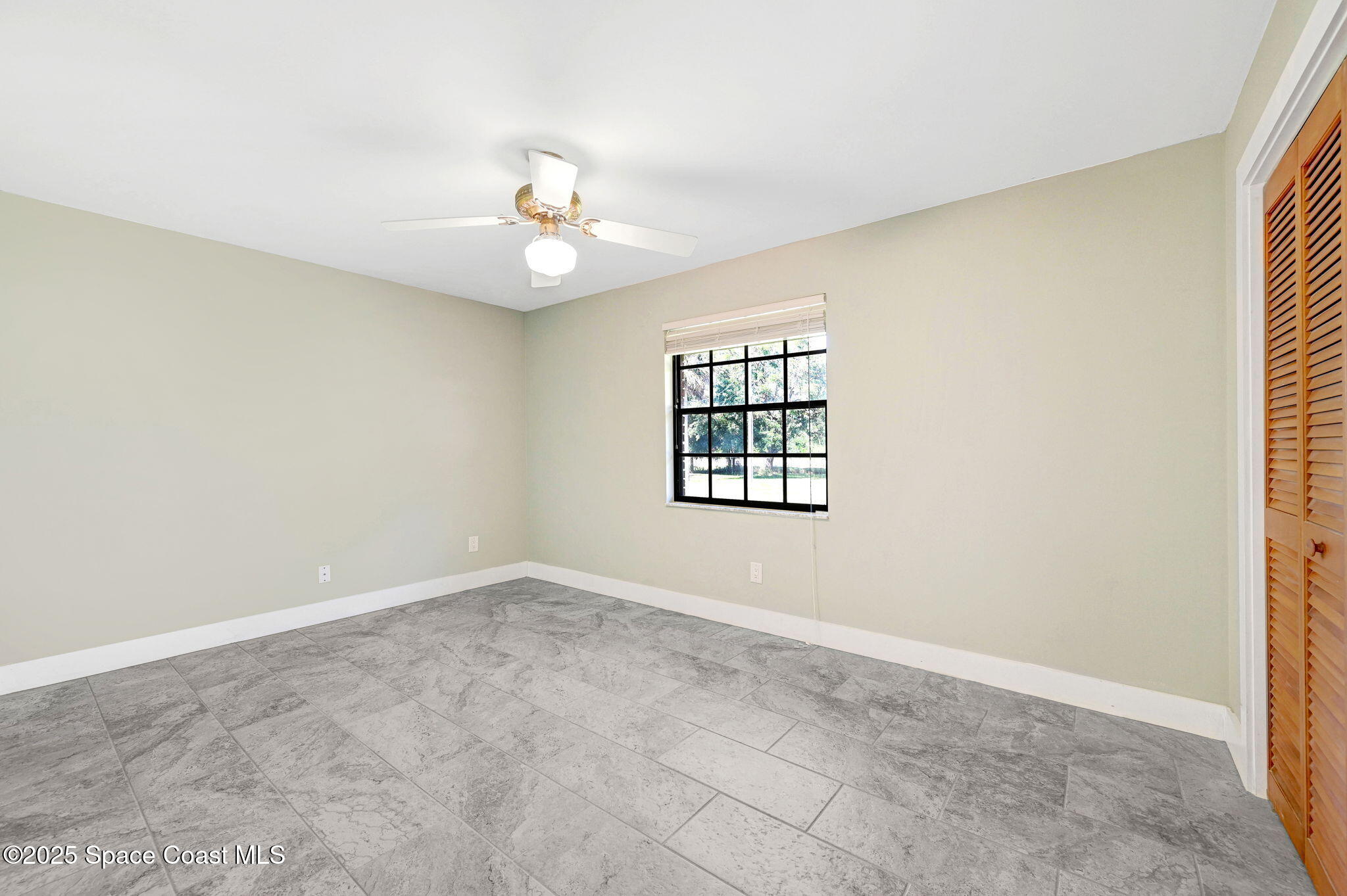 3301 Grant Road Grant-Valkaria, FL 32949 - Photo 25 of 56 an empty room with windows and ceiling fan