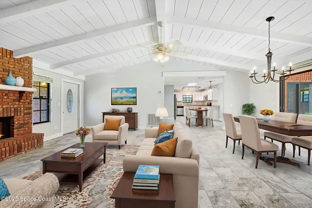 a living room with furniture a chandelier and a dining table