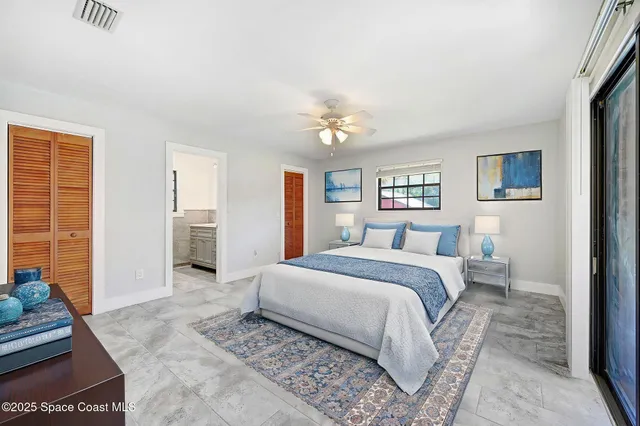 a spacious bedroom with a large bed and a chandelier