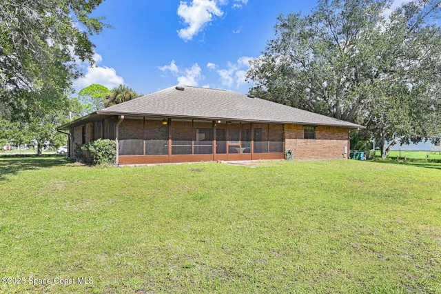 a backyard of a house with table and chairs