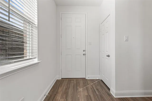 a view of a room with wooden floor and a window