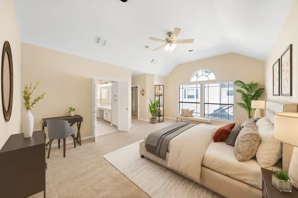 a spacious bedroom with a large bed and a chandelier