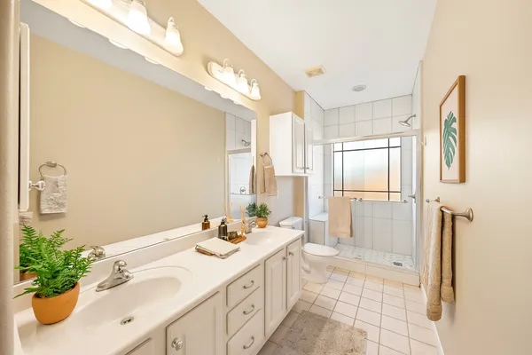 a spacious bathroom with a double vanity sink a mirror and a shower