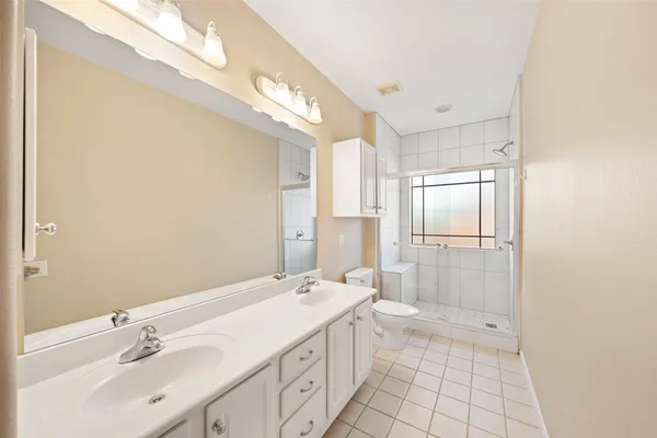 a bathroom with a double vanity sink mirror and shower