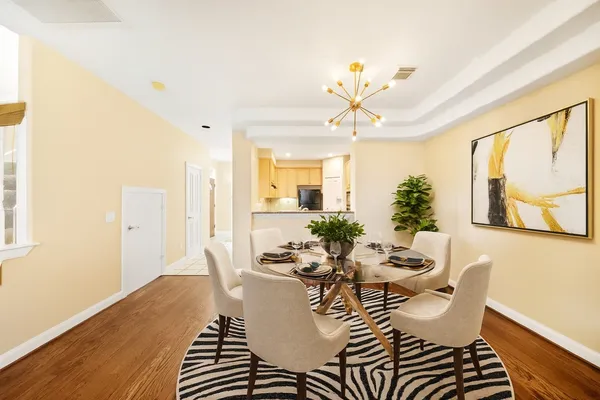 a view of a dining room with furniture a chandelier and wooden floor
