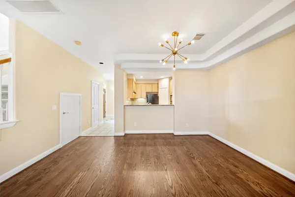 a view of a room with wooden floor and chandelier