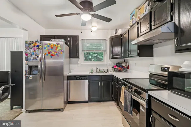 a kitchen with stainless steel appliances granite countertop a refrigerator a sink a stove and cabinets