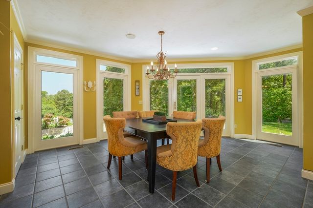 a dining room with furniture large windows and a chandelier