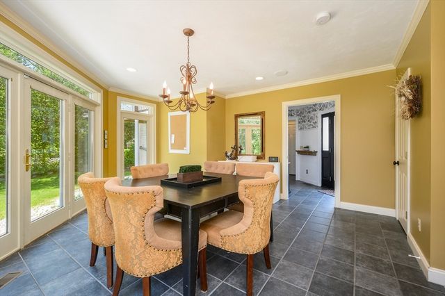 a dining room with furniture a chandelier and wooden floor