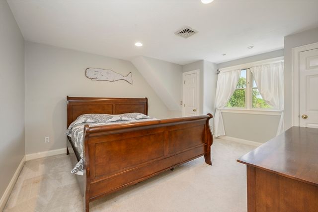 a bed sitting in a bedroom next to a window