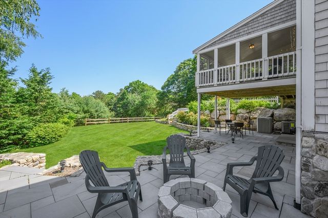 a view of a chair and table in the garden front of house