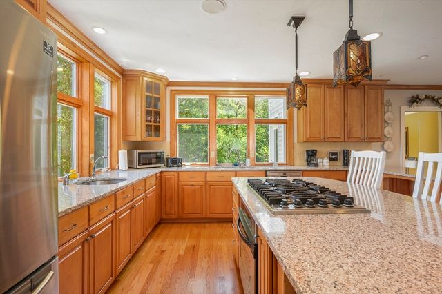 a kitchen with stainless steel appliances granite countertop a stove a sink and a refrigerator