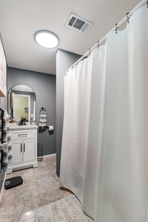 258 County Road Powderly, TX 75473 - Photo 16 of 24 a bathroom with a granite countertop sink and a mirror