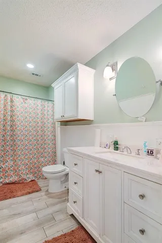 a bathroom with a double vanity sink toilet and a mirror