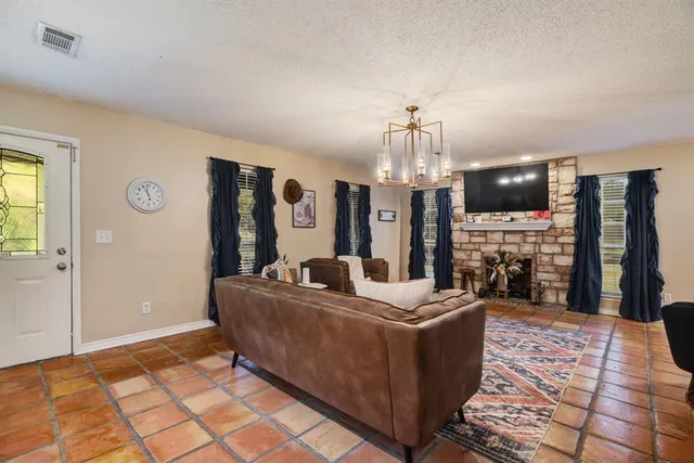a living room with fireplace furniture and a chandelier