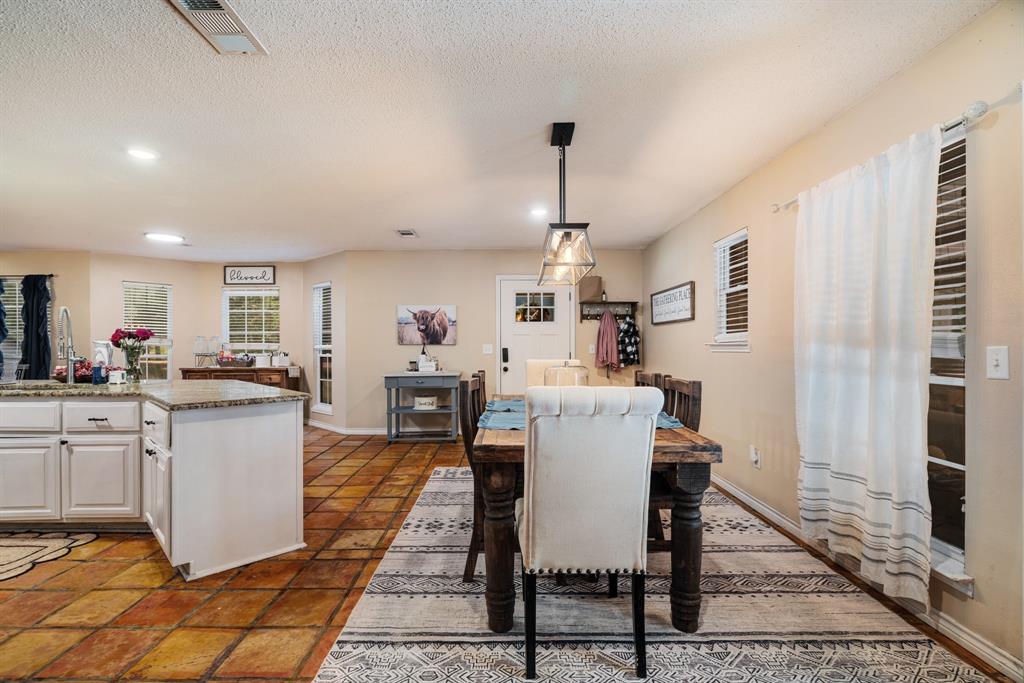 258 County Road Powderly, TX 75473 - Photo 6 of 24 a kitchen with a dining table chairs and white cabinets
