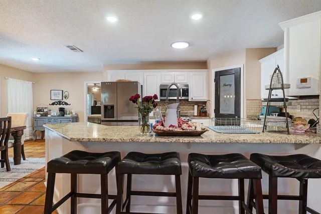 a kitchen with sink and chairs