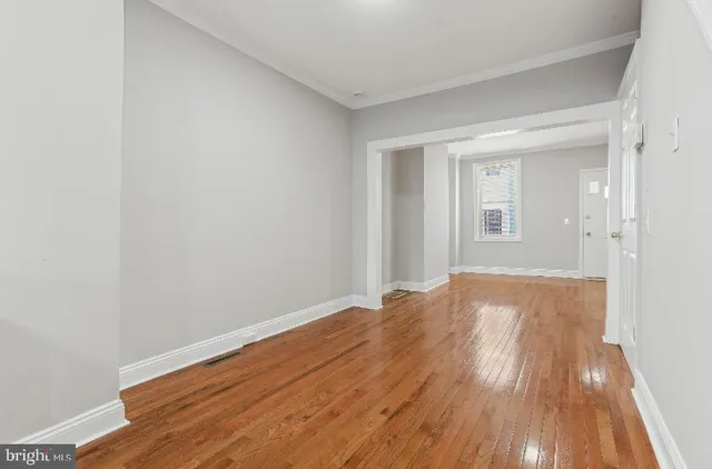 a view of empty room with wooden floor