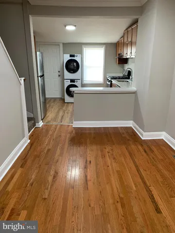 a view of a kitchen with a sink and dishwasher with wooden floor