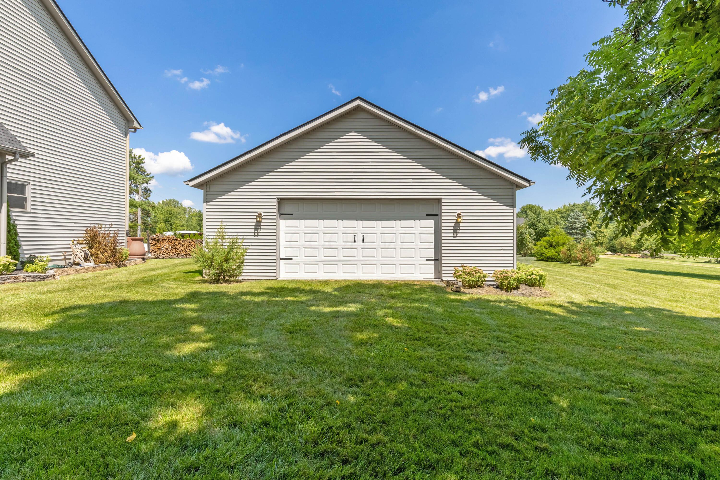 1515 Dale Ford Road Delaware, OH 43015 - Photo 58 of 74 • Vinyl exterior • 4 car tandem • Concrete flooring • Ceiling lights • Electric panel (tied to the house) • Dog door • Pegboard walls • Shelves • Golf net remains