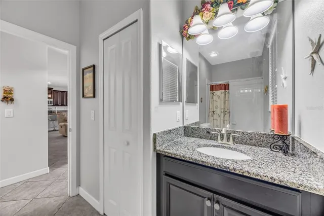 a bathroom with a granite countertop sink a mirror and a shower