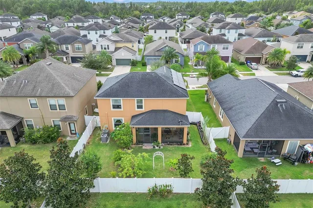 an aerial view of multiple houses with a yard