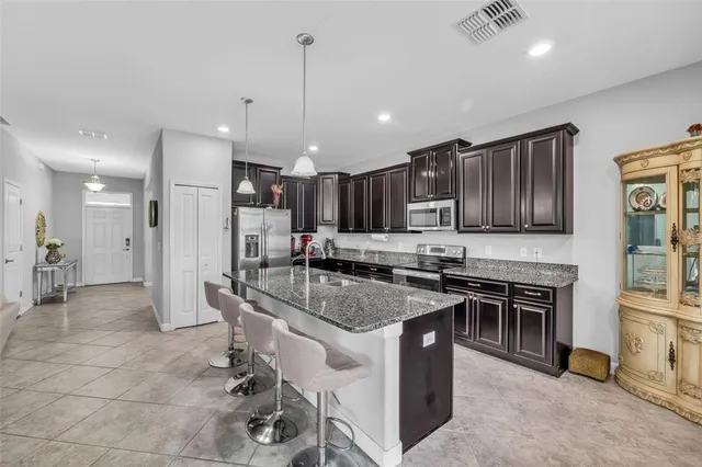 a kitchen with stainless steel appliances granite countertop a sink stove and refrigerator