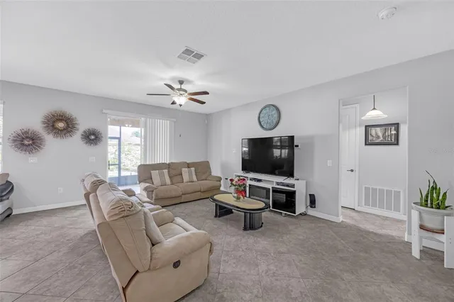 a living room with furniture a flat screen tv and a window