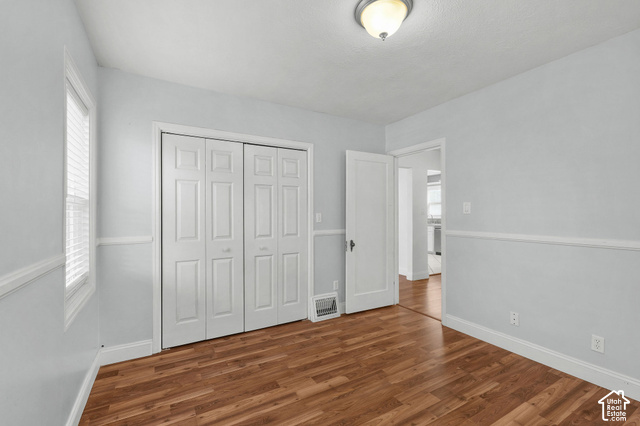 154 South State Street Morgan, UT 84050 - Photo 9 of 25 Wood-finish flooring, white bi-fold closet doors, white trim, and a semi-flush mount light fixture
