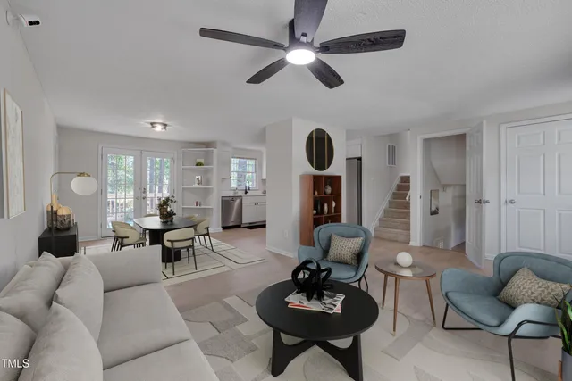 a living room with furniture a rug and white walls