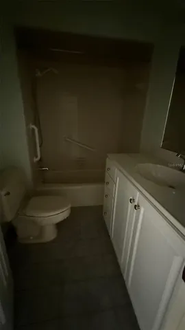 a bathroom with a granite countertop toilet and a sink