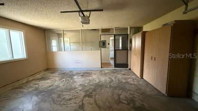 a view of empty room with windows and refrigerator