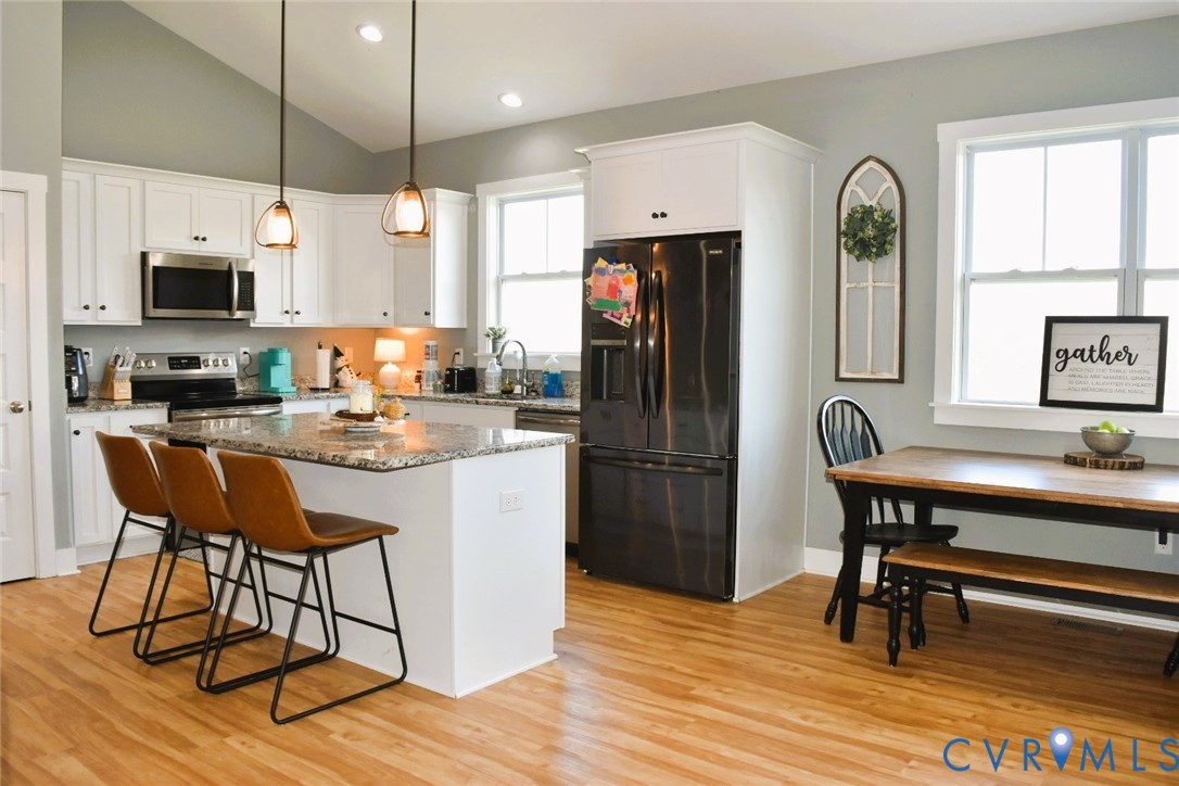 288 Moore Road Farmville, VA 23901 - Photo 15 of 33 a kitchen with stainless steel appliances granite countertop a refrigerator a stove a sink dishwasher a dining table and chairs with wooden floor