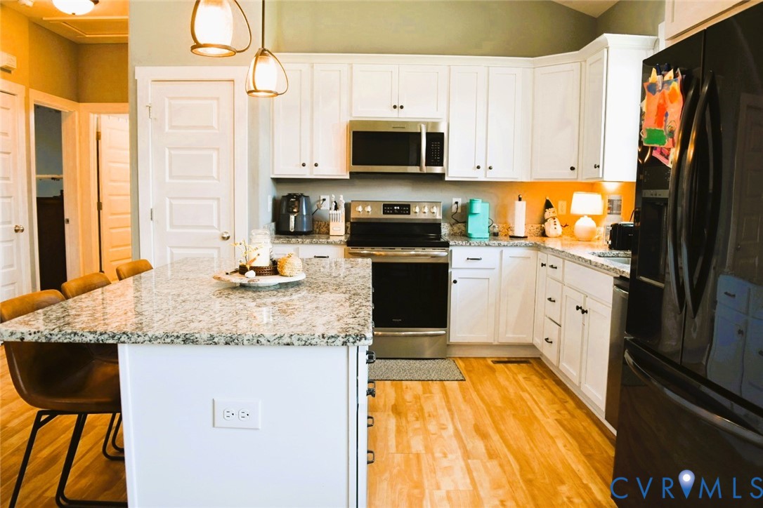 288 Moore Road Farmville, VA 23901 - Photo 17 of 33 a kitchen with granite countertop a stove top oven microwave and cabinets