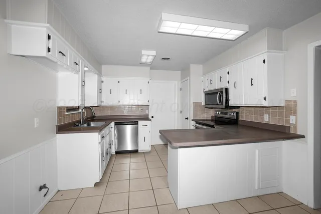 a kitchen with a sink a stove and cabinets