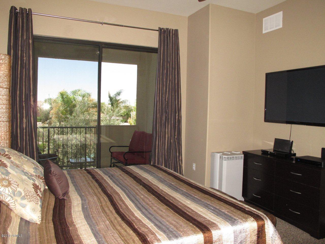 3330 South Gilbert Road, Unit 2014 Chandler, AZ 85286 - Photo 11 of 30 a bedroom with a bed and a flat tv screen next to a window