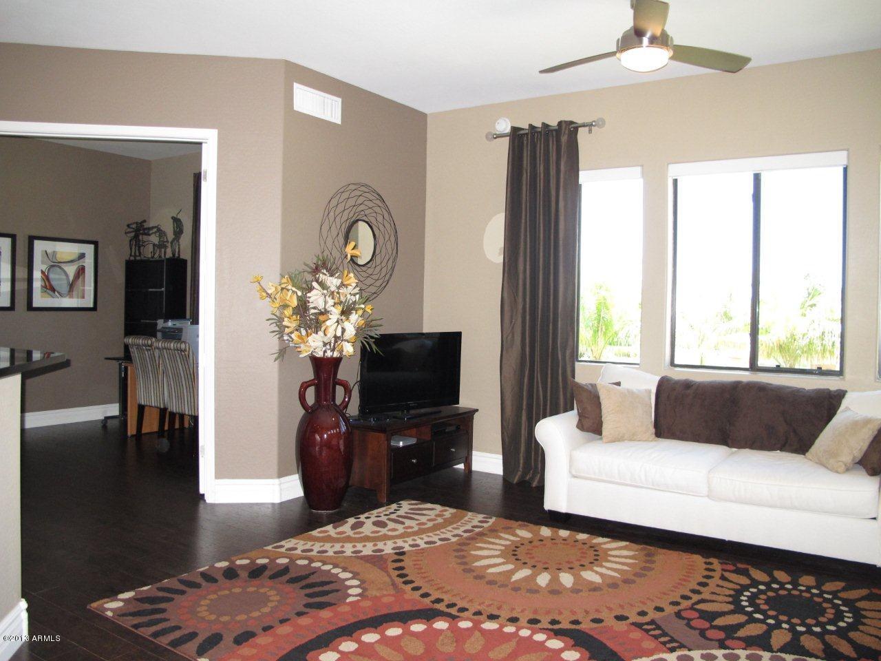 3330 South Gilbert Road, Unit 2014 Chandler, AZ 85286 - Photo 4 of 30 a bedroom with a bed a couch and a chandelier
