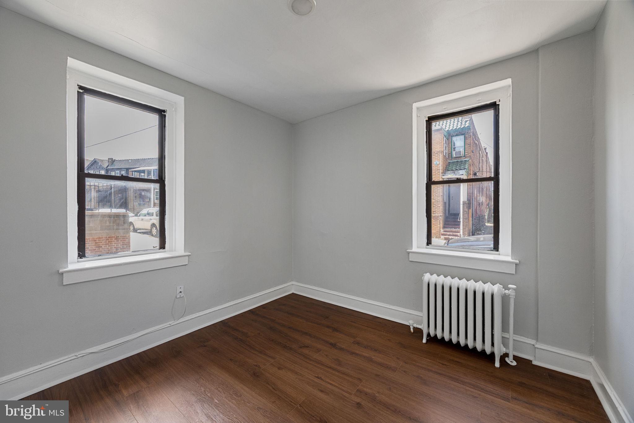 0 Garrett Road, Unit F101 Upper Darby, PA 19082 - Photo 14 of 22 a view of an empty room with wooden floor and a window