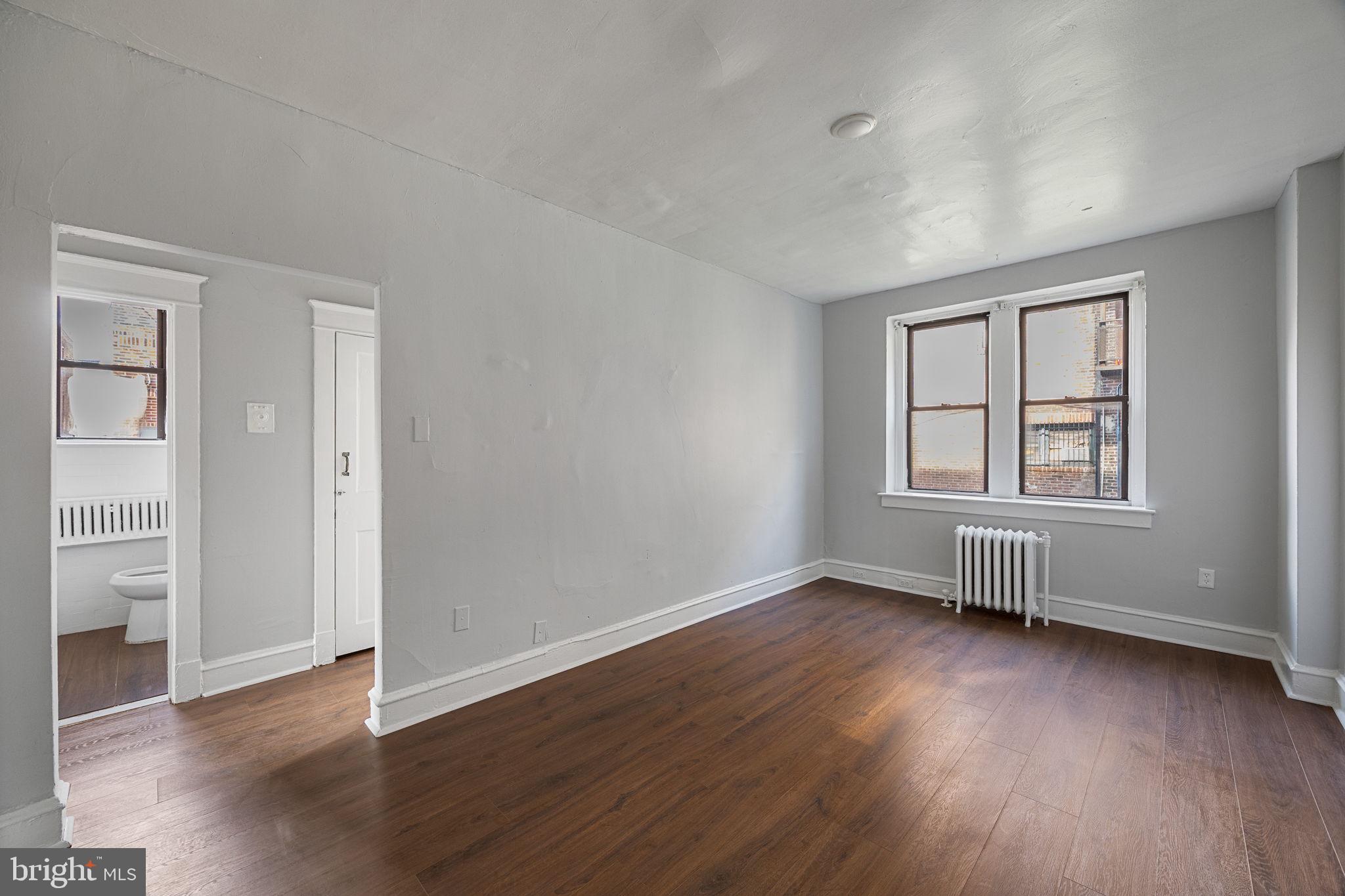 0 Garrett Road, Unit F101 Upper Darby, PA 19082 - Photo 6 of 22 an empty room with wooden floor and windows
